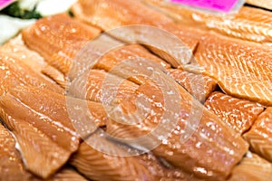 Close up of salmon fillets spread over ice on a fish mongerÃ¢â¬â¢s